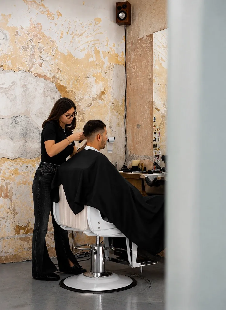 Un barbero cortando el pelo a un cliente en BART Barbershop